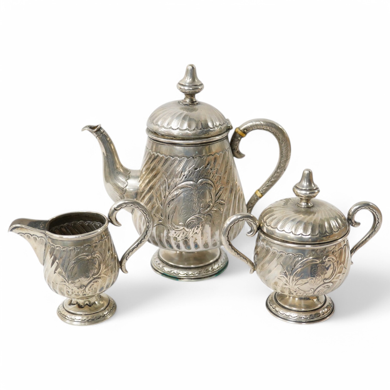 A German 800 standard white metal three piece pedestal tea set, with horn insulators and spiral fluted decoration, gross weight 15.5oz. Condition - poor